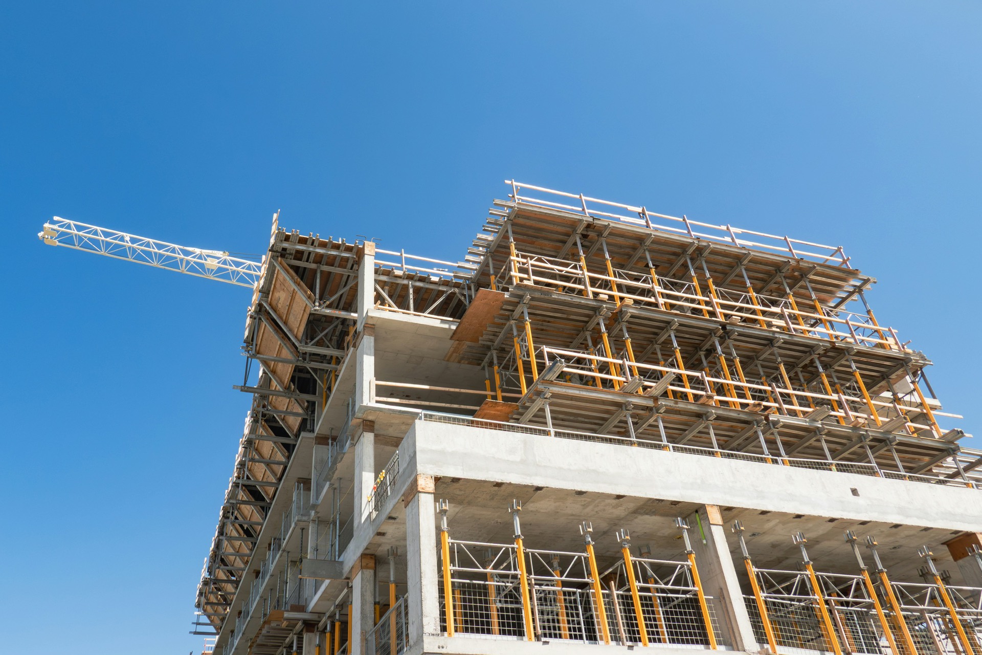 Multi-storey commercial building under construction with a tower crane