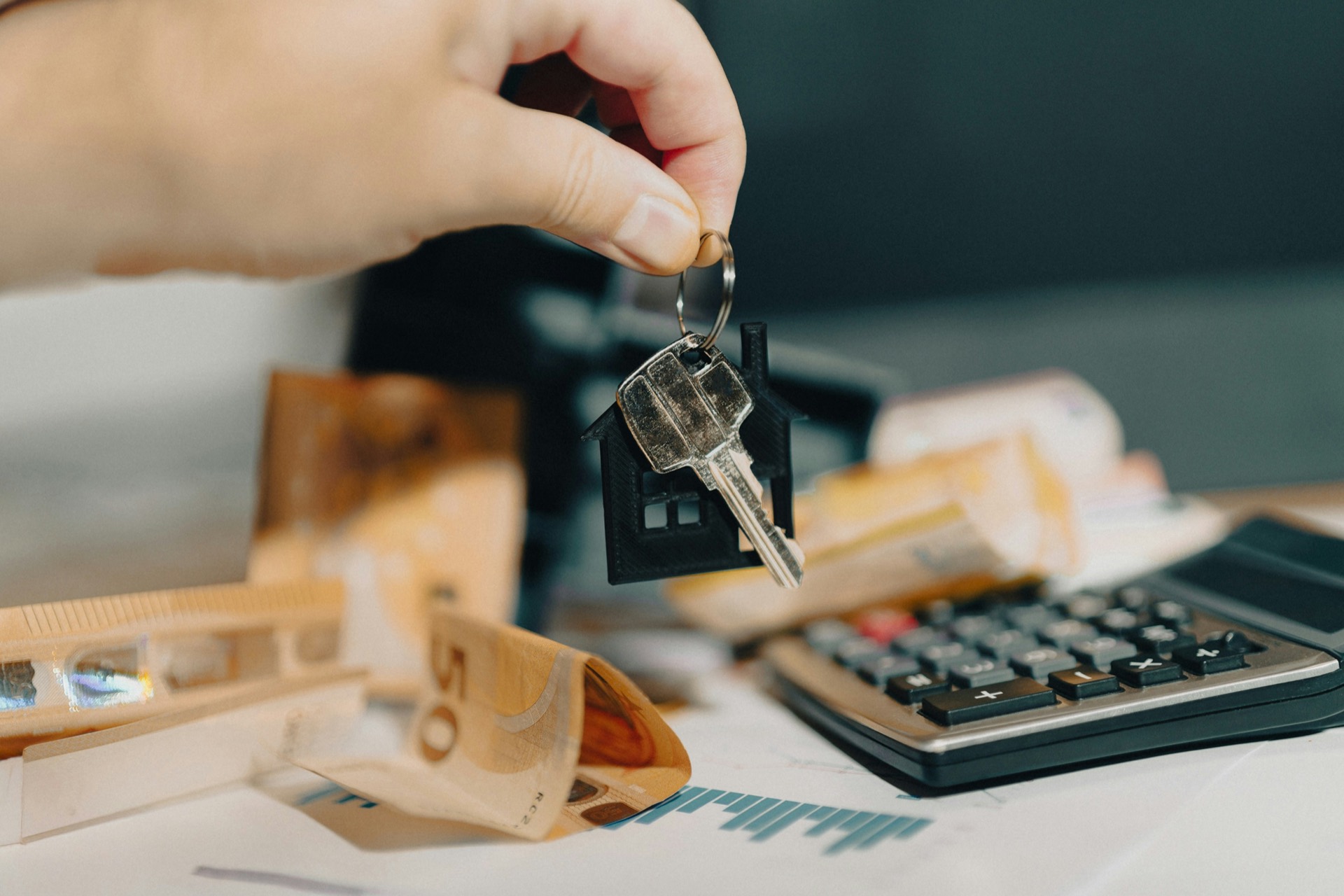 Keys being handed over above paperwork and a calculator